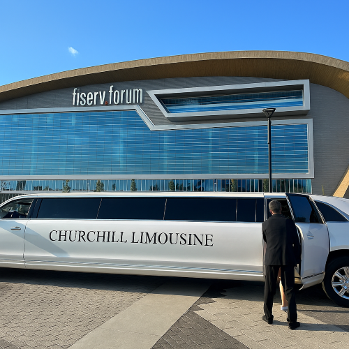 White stretch limousine parked at Fiserv Forum in Milwaukee with Churchill Limousine branding.