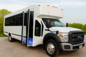 White Ford shuttle bus parked on a suburban road with tinted windows and chrome grille.