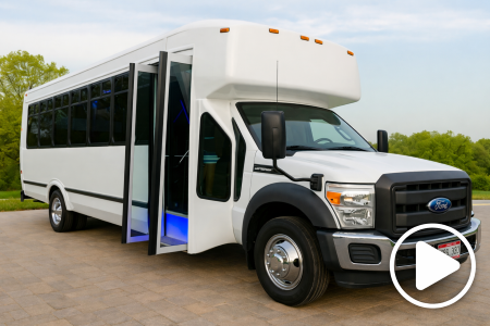 White Ford shuttle bus parked on a suburban road with tinted windows and black grille.