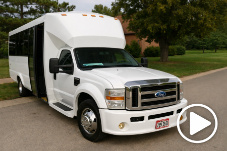 White Ford shuttle bus parked on a suburban road with tinted windows and chrome grille.
