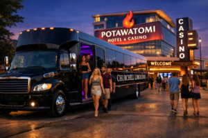 Black Churchill Limousine party bus dropping off guests at Potawatomi Hotel and Casino at night.
